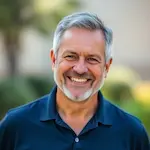 Portrait of Robert Mitchell, confident 55-year-old man with short gray hair and warm smile